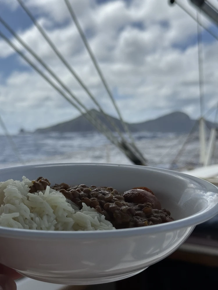 Curry mit Reis auf einem Segelboot - im Hintergrund sieht man die karibischen Inseln.